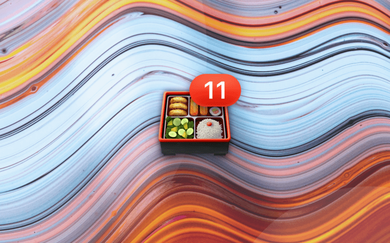 Bento box emoji with number 11 badge resting on a abstract waving background