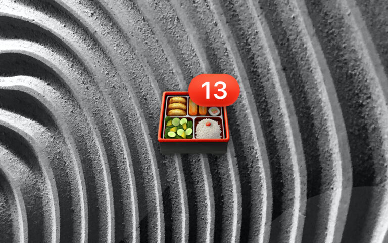 Bento box emoji with number 13 badge resting on a grayscale textured wavy background
