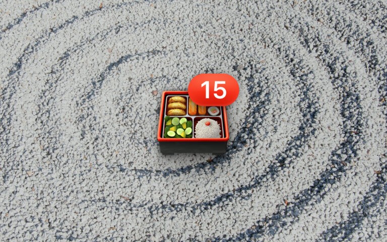 Bento box emoji with number 15 badge resting on a grayscale rock wave