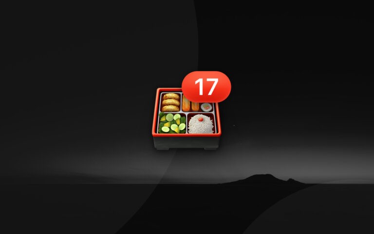 Bento box emoji with number 17 badge resting on a faded sunset